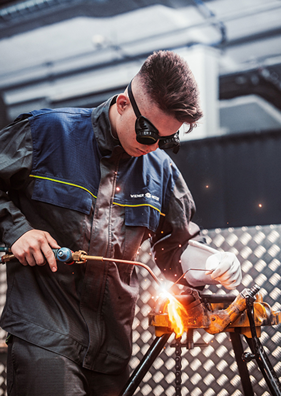 An apprentice welding a component.