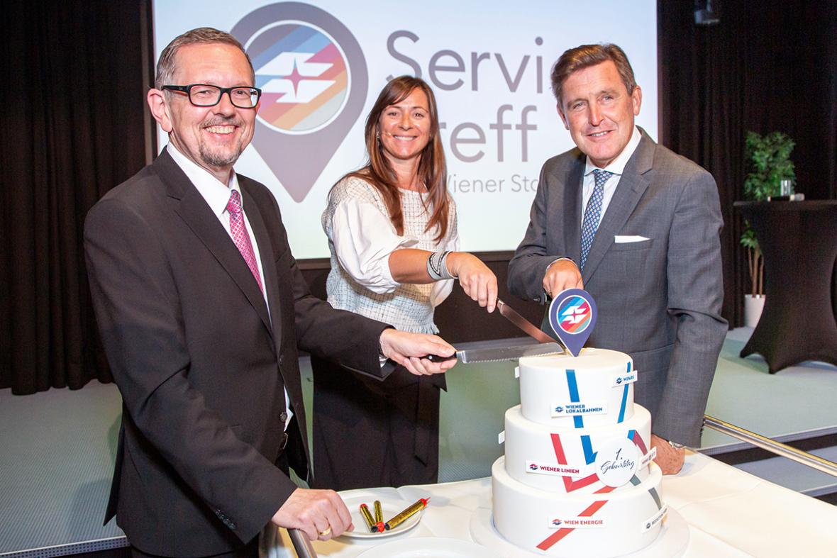 Generaldirektor Martin Krajcsir, Stadtrat Peter Hanke und Irene Antunovic, Leiterin des Service Treff, schneiden die Geburtstagstorte an.